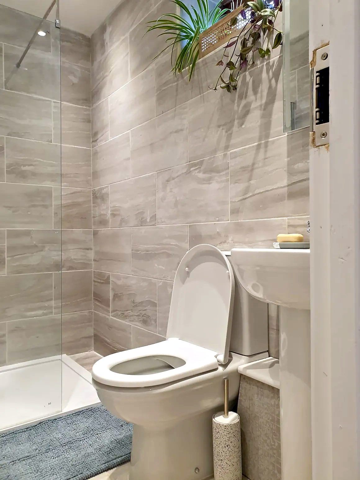 Compact shower room with wood-effect wall tiles, WC and basin