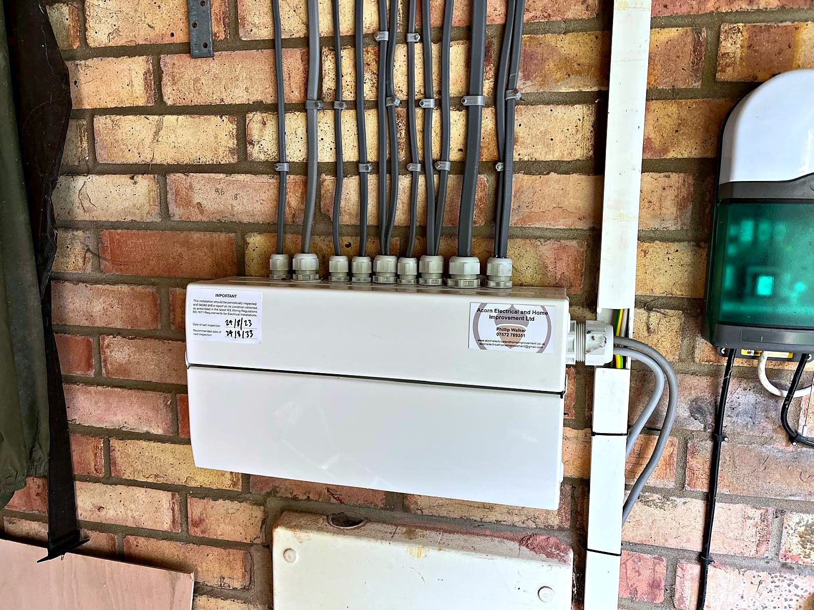 Newly installed consumer unit with neatly dressed cables on a garage brick wall