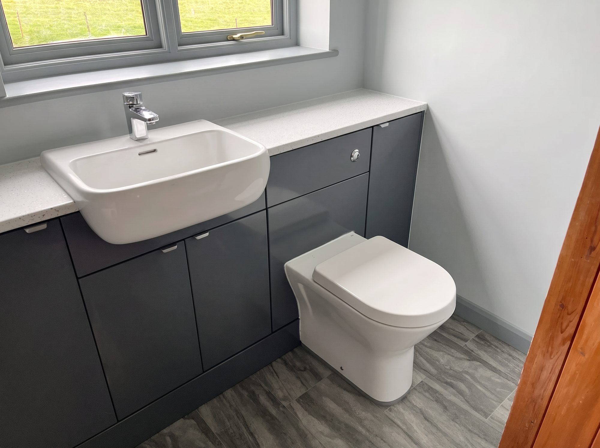 Bathroom with graphite fitted furniture, sparkle worktop and concealed cistern WC