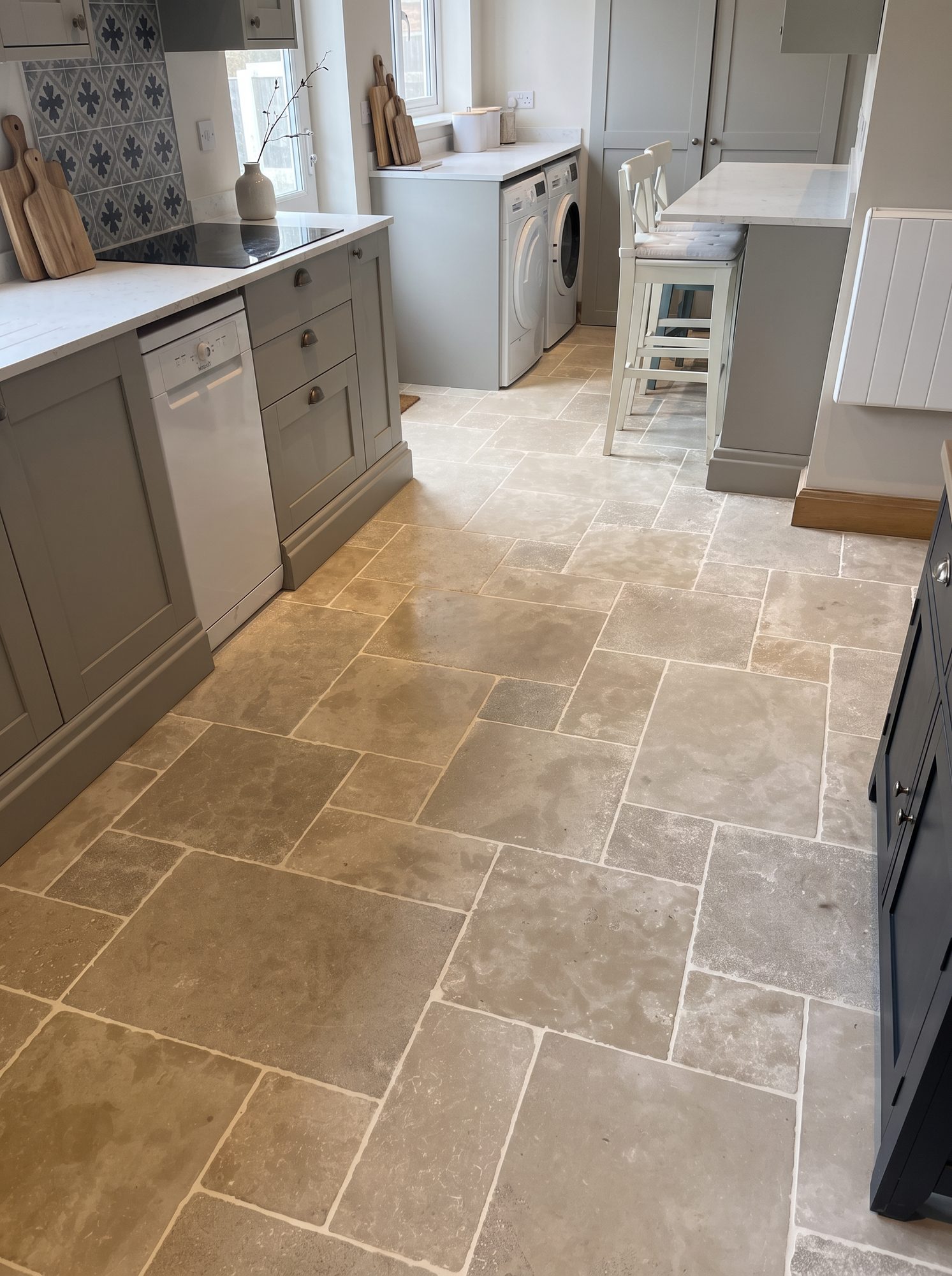 Aged limestone flagstone kitchen floor laid through to a utility area